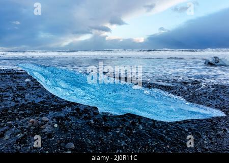 Eisberg-Reste wuschen am Strand von Jökulsarlön, wo Eisberge aus der Jökulsarlön-Lagune in Island fließen Stockfoto