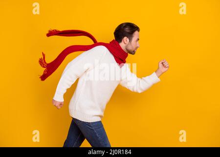 Profil Foto von sportlichen Wettbewerb Kerl laufen Wettbewerb Konzept tragen roten Schal weiß Pullover isoliert gelben Hintergrund Stockfoto