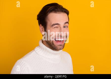 Foto von lustigen charmanten Kerl tragen weißen Pullover lächelnd winken isoliert gelben Hintergrund Stockfoto