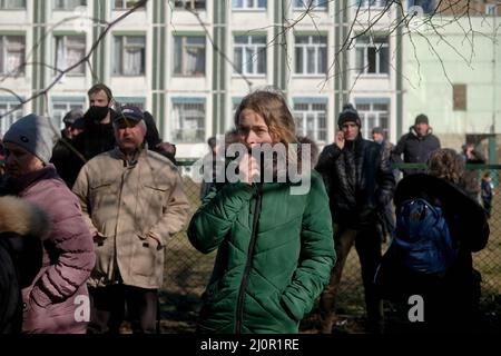Kiew, Ukraine. 20. März 2021. Die Bewohner beobachten, wie Notfallpersonal auf die Folgen einer Raketenlandung in der Nähe eines Wohngebäudes reagiert, nachdem es im Kiewer Stadtteil Bilychi aus dem Himmel geschossen wurde. Eine Rakete wurde aus dem Himmel geschossen und landete in der Nähe eines Wohngebäudes im Stadtteil Bilychi in Kiew, Ukraine, und verursachte Schäden an den Gebäuden und Verletzungen der Bewohner. Kredit: SOPA Images Limited/Alamy Live Nachrichten Stockfoto