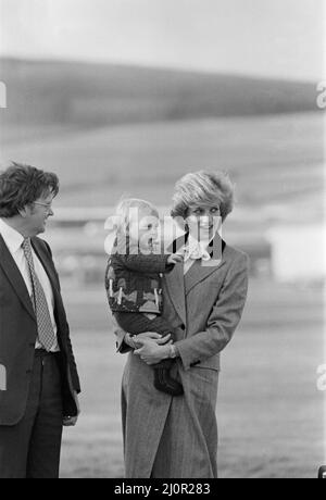 Ihre Königliche Hoheit Prinzessin Diana, die Prinzessin von Wales, hält ihren Sohn Prinz William fest, bevor sie am Flughafen Aberdeen, Schottland, in das königliche Flugzeug steigen. Bild 3 von 4 in dieser Sequenz von 4 Bildern bittet Prinzessin Diana Prinz William zu winken. Er versteht es nicht, also winkt er nicht. Und so winkt Prinzessin Diana, und bald winkt Prinz William mit ihr. Kopiert seine Mutter. Dies ist möglicherweise eine frühe, sogar erste, königliche Welle von einem damals 16. Monate alten Prinz William. Bild aufgenommen am 24.. Oktober 1983 Stockfoto