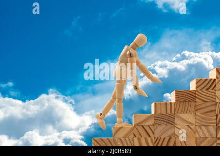 Dummy auf Holztreppe, die zum Himmel führt Stockfoto