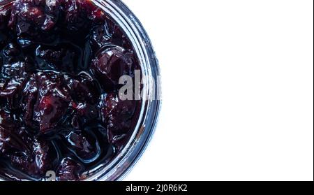 Draufsicht auf saure Kirschmarmelade im Glasglas. Bio-saure Kirschmarmelade isoliert auf weißem Hintergrund. Stockfoto