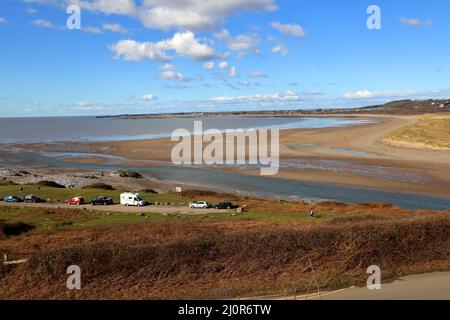 Der Blick über die Newton Bay über den Fluss Ogmore, wo er in den Bristol-Kanal mündet, zeigt den fast voll ausgelauften River Mouth-Parkplatz. Stockfoto