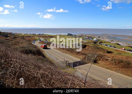 Der schnell auffüllende Rivermouth-Parkplatz in Ogmore am Meer zeigt das R.N.L.I.-Gebäude und den Fluss, der sich mit den Gewässern des Bristol Channel verbindet. Stockfoto