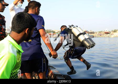 Narayanganj, Bangladesch. 20. März 2022. Taucher tauchen in den Fluss Shitalakshya in Narayanganj während der Rettungsaktion nach einem Start kenterte. Mindestens sechs Menschen starben und Dutzende bleiben vermisst, als ein Start kenterte, nachdem er am Sonntagnachmittag von einem Frachtschiff getroffen wurde. Kredit: SOPA Images Limited/Alamy Live Nachrichten Stockfoto