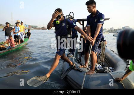 Narayanganj, Bangladesch. 20. März 2022. Taucher tauchen in den Fluss Shitalakshya in Narayanganj während der Rettungsaktion nach einem Start kenterte. Mindestens sechs Menschen starben und Dutzende bleiben vermisst, als ein Start kenterte, nachdem er am Sonntagnachmittag von einem Frachtschiff getroffen wurde. Kredit: SOPA Images Limited/Alamy Live Nachrichten Stockfoto