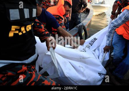 Narayanganj, Bangladesch. 20. März 2022. (ANMERKUNG DER REDAKTION: Das Bild zeigt den Tod) das Rettungsteam erholt Leichen am Fluss Shitalakshya in Narayanganj. Mindestens sechs Menschen starben und Dutzende bleiben vermisst, als ein Start kenterte, nachdem er am Sonntagnachmittag von einem Frachtschiff getroffen wurde. Kredit: SOPA Images Limited/Alamy Live Nachrichten Stockfoto