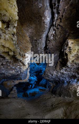 Innenraum der Höhle mit blauem Licht und Kristall. Wanderweg für Touristen. Alte Steinformationen. Konzept von Ausflügen und Attraktionen Stockfoto
