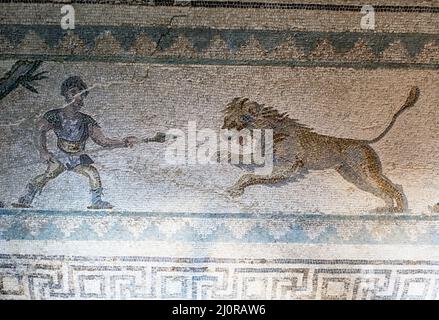 Haus von Dionysos, Paphos, Zypern: Jagdszene das römische Bodenmosaik zeigt einen Mann mit einem Speer, der einen auflagenden Löwen jagt Stockfoto