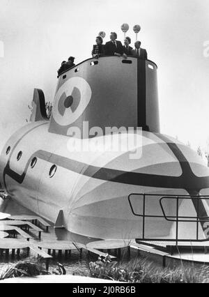 The Yellow Submarine in Liverpool, eine große Modelldarstellung des U-Bootes aus dem Animationsfilm Yellow Submarine, inspiriert vom gleichnamigen Lied auf dem Beatles-Album Revolver. Es wurde von einer Gruppe von etwa 80 Auszubildenden von Cammell Laird's Werft für die Ausstellung auf dem International Garden Festival in Liverpool im Jahr 1984 gebaut. Bild zeigt: Der rechte Hon. Michael Heseltine MP, der Verteidigungsminister, der kurz vor der offiziellen Eröffnung an Bord der Sub auf dem Ausstellungsgelände abgebildet ist. 1. Mai 1984. Stockfoto