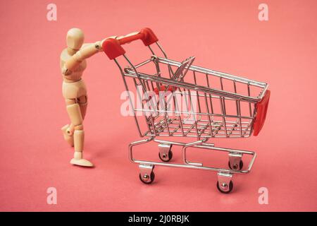Holzmann schiebt einen leeren Warenkorb Stockfoto