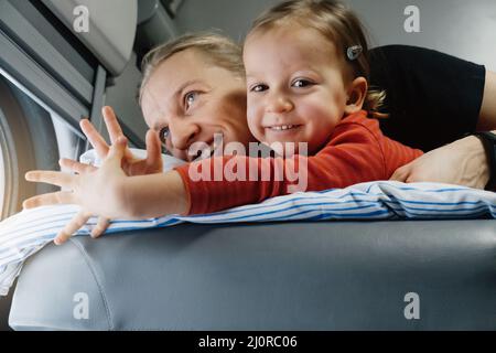 Vater mit Kind travalling in den Zug, Spaß zu genießen Szene durch Fenster, während auf der Eisenbahn zusammen im Schlafwagen fahren Stockfoto