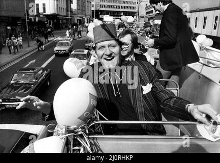 Der Komiker Tommy Cooper machte eine offene Busreise durch die Straßen von Newcastle. Die Reise wurde vom Kaufhaus Farnons organisiert, dessen Verkauf eröffnet werden sollte. Eine traditionelle Jazzband ritt mit ihm, um die Aufmerksamkeit der Menschen zu erregen. Dann überreichte Tommy den Gewinnern im Store Preise und signierte Autogramme für seine Fans - einfach so!. 2.. April 1983 Stockfoto