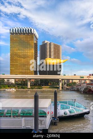 tokio, japan - oktober 28 2021: Die goldene Flammenskulptur des Asahi Beer Headquarter Building, entworfen von Starck, und ein Wasserbus, entworfen von Manga Art Stockfoto