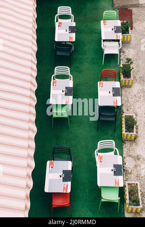 Blick von oben auf Tische mit Stühlen in einem Straßencafé Stockfoto