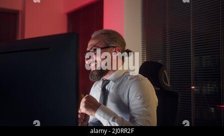 Glücklicher, gutaussehender Büroangestellter im mittleren Alter, der im Büro lachte Stockfoto