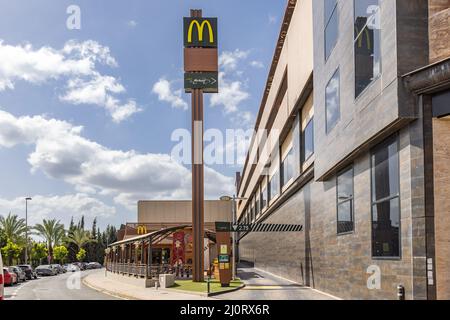 Huelva, Spanien - 19. März 2022: McDonald's McAuto Drive am Eingang. McDonald's ist ein US-amerikanischer multinationaler Fast-Food-Konzern, der 1940 AS gegründet wurde Stockfoto