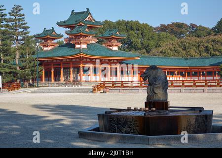 Drachenstatue über dem Wasserwaschbecken mit Byakko-ro Turm des Heian-jingu Schreins. Kyoto. Japan Stockfoto