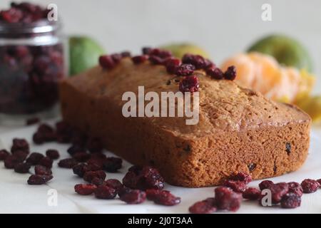 Orange Cranberry Brot. Ein schnelles Brot mit Orangengeschmack und getrockneten Preiselbeeren. Ein perfekter Begleiter zum Kaffee. Aufgenommen auf weißem Hintergrund mit getrockneten Stockfoto