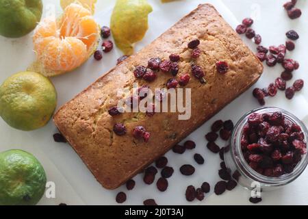 Orange Cranberry Brot. Ein schnelles Brot mit Orangengeschmack und getrockneten Preiselbeeren. Ein perfekter Begleiter zum Kaffee. Aufgenommen auf weißem Hintergrund mit getrockneten Stockfoto