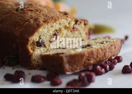 Brotscheibe aus Orangenbeeren in Scheiben. Ein schnelles Brot mit Orangengeschmack und getrockneten Preiselbeeren. Ein perfekter Begleiter zum Kaffee. Stockfoto