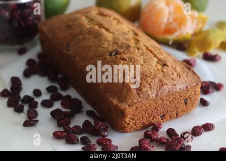 Orange Cranberry Brot. Ein schnelles Brot mit Orangengeschmack und getrockneten Preiselbeeren. Ein perfekter Begleiter zum Kaffee. Aufgenommen auf weißem Hintergrund mit getrockneten Stockfoto