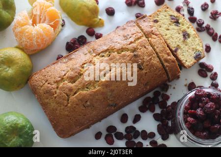 Brotscheibe aus Orangenbeeren in Scheiben. Ein schnelles Brot mit Orangengeschmack und getrockneten Preiselbeeren. Ein perfekter Begleiter zum Kaffee. Stockfoto