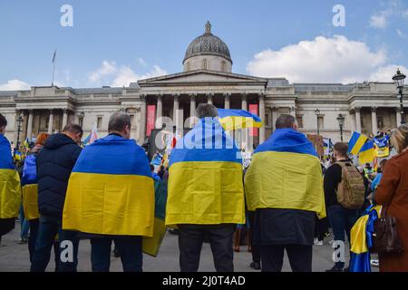 London, Großbritannien. 20.. März 2022. Demonstranten hüllen sich in ukrainische Fahnen. Auf dem Trafalgar-Platz versammeln sich weiterhin große Menschenmengen zur Unterstützung der Ukraine, während Russland seinen Angriff verstärkt. Kredit: Vuk Valcic/Alamy Live Nachrichten Stockfoto