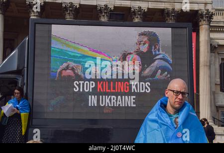 London, Großbritannien. 20.. März 2022. Auf dem Bildschirm wird „Stoppt das Töten von Kindern in der Ukraine“ angezeigt. Auf dem Trafalgar-Platz versammeln sich weiterhin große Menschenmengen zur Unterstützung der Ukraine, während Russland seinen Angriff verstärkt. Kredit: Vuk Valcic/Alamy Live Nachrichten Stockfoto