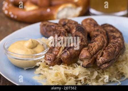 Nürnberger Würstchen mit Sauerkraut auf dem Teller Stockfoto