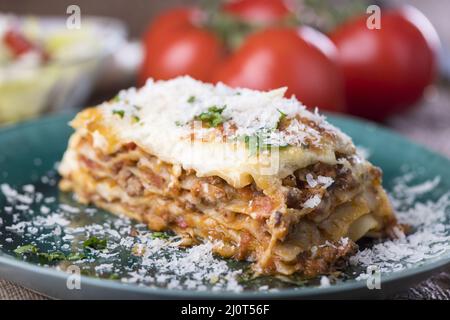 Portion Lasagne auf einem grünen Teller Stockfoto