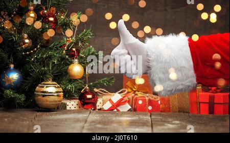 Die Hand des Weihnachtsmanns zeigt die Daumen nach oben. Stockfoto