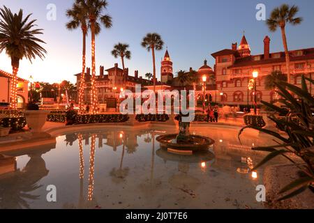 Die Dämmerungsansicht des Flagler College mit dem Brunnen im Lightner Museum Park/City Hall Park im Vordergrund.St.Augustine.Florida.USA Stockfoto