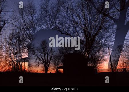 Doppelbelichtung eines verlassenen Bauernhauses im amerikanischen Mittleren Westen bei Sonnenuntergang Stockfoto