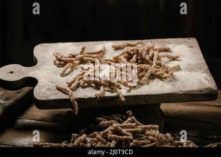 Rohe Pasta busiate auf Holztisch Nahaufnahme Stockfoto