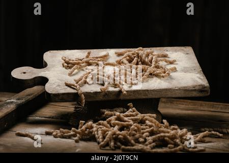 Rohe Pasta busiate auf Holztisch Nahaufnahme Stockfoto