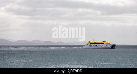 Panoramablick auf die Fred Olsen Express Fähre unterwegs zwischen Lanzarote und Fuerteventura mit Fuerteventura im Hintergrund auf den Kanarischen Inseln, Sp Stockfoto