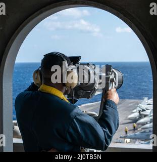 220122-N-AV223-1099 PHILIPPINISCHES MEER (JAN 22, 2022) Seaman Ethan Burney, ein gebürtiger aus Lakewood, Ohio, beobachtet den Flugbetrieb an Bord des Nimitz-Klasse-Flugzeugträgers USS Carl Vinson (CVN 70), 22. Januar 2022. Als Teil der US-Pazifikflotte führen Einheiten, die Carl Vinson und Abraham Lincoln Carrier Strike Groups, America und Essex Amphibious Ready Groups gemeinsam mit der japanischen Maritime Self-Defense Force zugewiesen wurden, Schulungen durch, um eine freie und offene Region im Indo-Pazifik zu erhalten und zu schützen. (USA Navy Foto von Mass Communication Specialist Seaman Apprentice Derek Kelley) Stockfoto