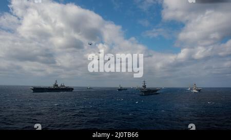 220122-N-PV401-1178 PHILIPPINISCHES MEER (JAN 22, 2022) Flugzeuge, die Carrier Air Wing (CVW) 2 und CVW 9 zugewiesen wurden, fliegen über die philippinische See als Nimitz-Klasse Flugzeugträger USS Carl Vinson (CVN 70) und USS Abraham Lincoln (CVN 72), Japan Maritime Self-Defense Force (JMSDF) Hyuga-Klasse Hubschrauber-Zerstörer JS Hyuga (DDH 181), America-Klasse amphibisches Sturmschiff USS America (LHA 6), Wasp-Klasse amphibisches Sturmschiff USS Essex (LHD 2), Ticonderoga-Klasse geführte Raketen Kreuzer USS Mobile Bay (CG 53) und USS Lake Champlain (CG 57), und Arleigh Burke-Klasse geführte Raketen Zerstörer USS Spruance (DDG Stockfoto