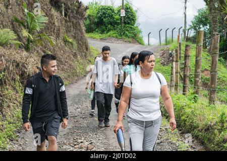 Eine Gruppe von Menschen wandern hoch in den kolumbianischen Bergen. Familie auf einem Feldweg. Die Menschen schauen sich die wunderschöne Natur der Wälder an. Stockfoto