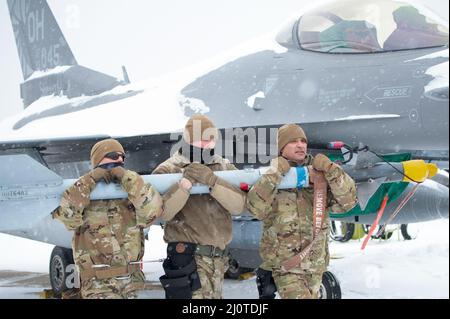 Waffenlader der US-Luftwaffe, Master Sgt. Steve Przyojski, Technik. Sgt. Adam Pawlicki und Meister Sgt. Tom Gonzalez (von links), der dem 180. Fighter Wing der Ohio National Guard zugewiesen wurde, trotzt der Kälte und dem Schnee, um eine Trainingsflugwaffe, die als AIM-9 bezeichnet wird, am 24. Januar 2022 zu entladen. Der 180FW führt tägliche Schulungen durch, die in realistischen Umgebungen unter realistischen Bedingungen durchgeführt werden, um sicherzustellen, dass unsere Truppen das höchste Niveau an Kompetenz und Bereitschaft für den weltweiten Einsatz aufrechterhalten. Foto der US Air National Guard von Senior Master Sgt. Beth Holliker. Stockfoto