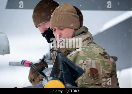 Waffenlader der US-Luftwaffe, Tech. Sgt. Adam Pawlicki und Meister Sgt. Tom Gonzalez (von links), der dem 180. Fighter Wing der Ohio National Guard zugewiesen wurde, trotzt der Kälte und dem Schnee, um eine Trainingsflugwaffe, die als AIM-9 bezeichnet wird, am 24. Januar 2022 zu entladen. Der 180FW führt tägliche Schulungen durch, die in realistischen Umgebungen unter realistischen Bedingungen durchgeführt werden, um sicherzustellen, dass unsere Truppen das höchste Niveau an Kompetenz und Bereitschaft für den weltweiten Einsatz aufrechterhalten. Foto der US Air National Guard von Senior Master Sgt. Beth Holliker. Stockfoto