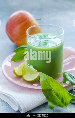 Grüner Smoothie mit Spinatblättern, Limettensaft und Apfel in einem Glas, Nahaufnahme Stockfoto