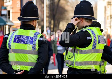 Cardiff, Wales - 2022. März: Rückansicht von zwei Polizisten, die im Stadtzentrum von Cardiff im Einsatz sind Stockfoto