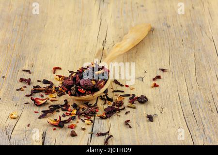 Holzlöffel mit getrocknetem Blumentee auf einem alten Holzhintergrund Nahaufnahme Stockfoto