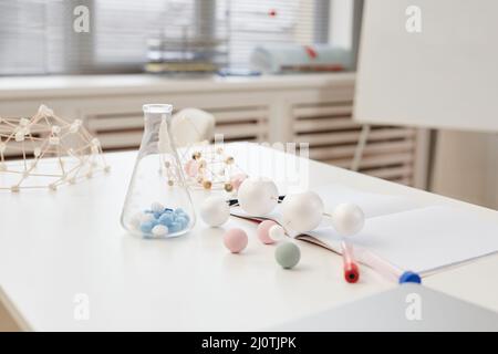 Minimales Hintergrundbild von Glasbechern und Molekülmodellen auf dem Tisch im Chemieunterricht in der Schule, Kopierraum Stockfoto