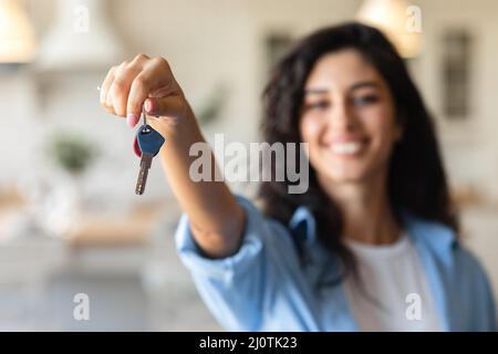 Fröhliche junge Frau mit den Wohnungsschlüsseln, Kauf oder Vermietung von Häusern, selektiver Fokus Stockfoto