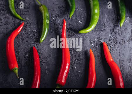 Auswahl an rohen Chilischoten. Gruppe von roten und grünen Paprika. Scharf und würzig. Stockfoto