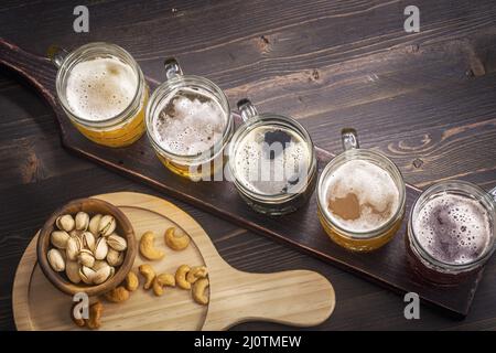 Verkostung verschiedener Biersorten mit Snacks auf dem Tisch Stockfoto